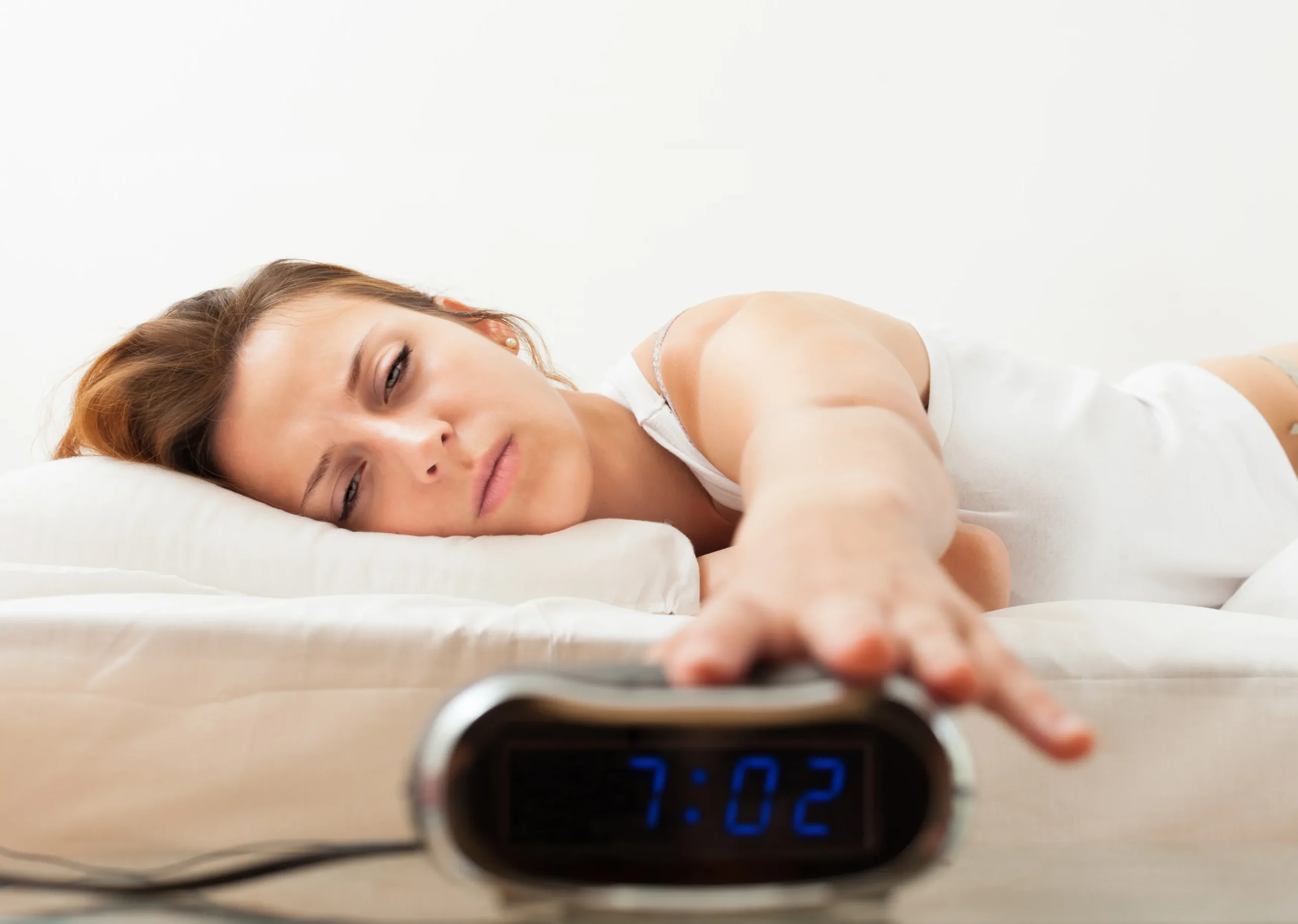 woman turns off alarm clock