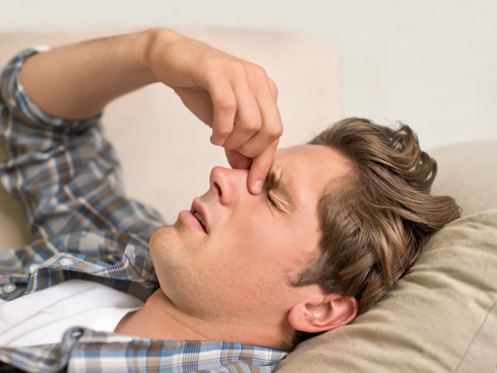 Woman with her nose blocked on one side pressing the side of her nose